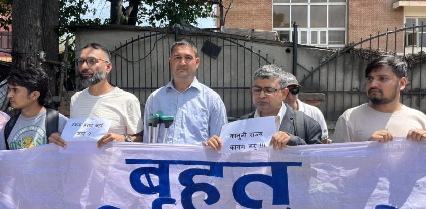 न्याय माग्न वैशाखी टेक्दै अदालतबाहिर प्रदर्शनमा पुगे उपप्राध्यापक प्रेम चलाउने